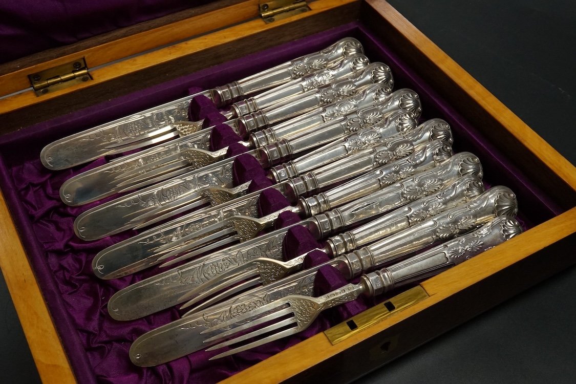 Twelve pairs of Victorian silver King's pattern dessert eaters, by John Gilbert, Birmingham, 1879/1880, loaded handles, in a mahogany canteen.